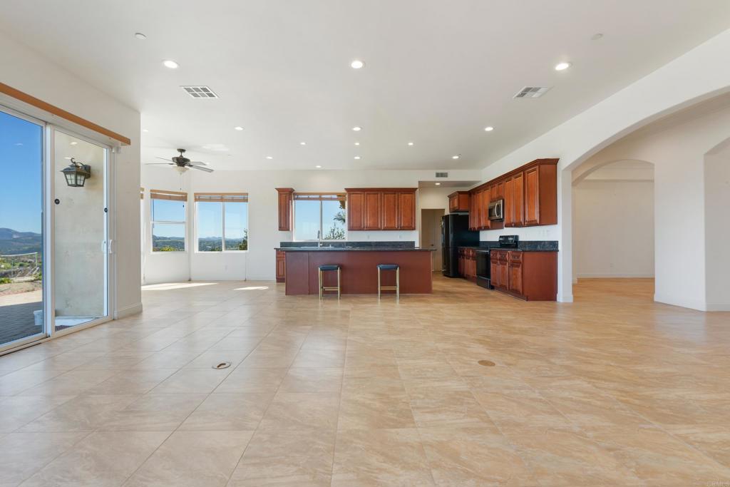 4261 Entrada Al Sol Bonsall, CA 92003 - Photo 10 of 49 a living room with stainless steel appliances furniture a large window and a kitchen view