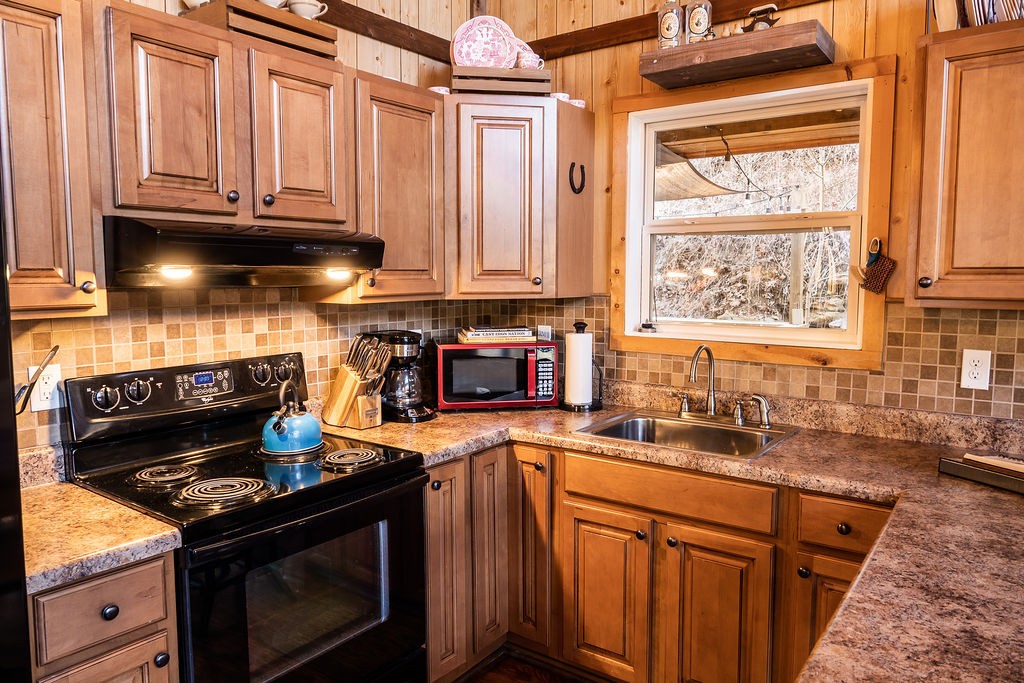 50 Hot Rock Hollow Road Fayetteville, TN 37334 - Photo 10 of 31 a kitchen with granite countertop a stove top oven cabinetry a sink and a window