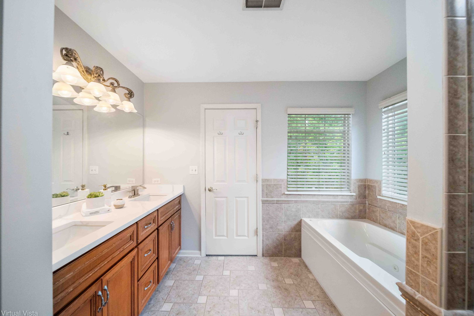 410 North River Road Naperville, IL 60540 - Photo 18 of 29 a bathroom with a tub a sink and a large mirror