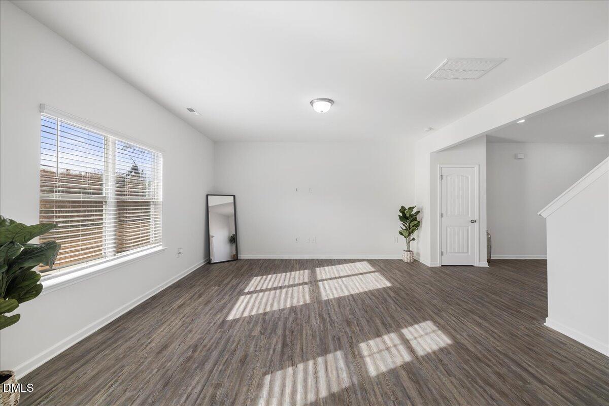 125 Flying Point Lane Clayton, NC 27520 - Photo 11 of 50 a view of an empty room with wooden floor and a window