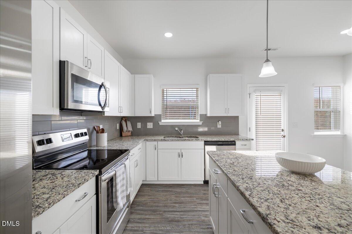 125 Flying Point Lane Clayton, NC 27520 - Photo 18 of 50 a kitchen with a stove top oven sink and cabinets