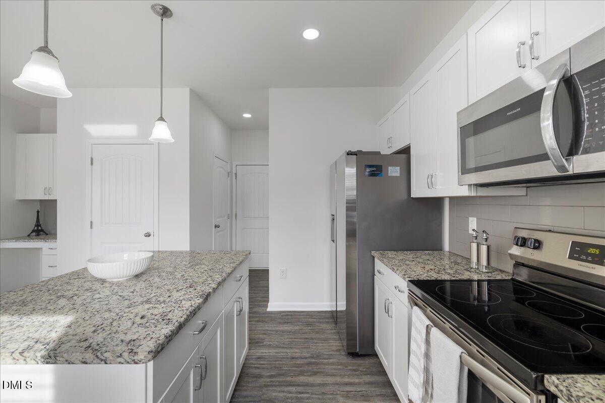 125 Flying Point Lane Clayton, NC 27520 - Photo 19 of 50 a kitchen with stainless steel appliances granite countertop a sink stove and microwave