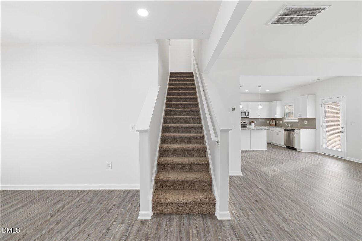 125 Flying Point Lane Clayton, NC 27520 - Photo 21 of 50 a view of a kitchen with wooden floor and staircase