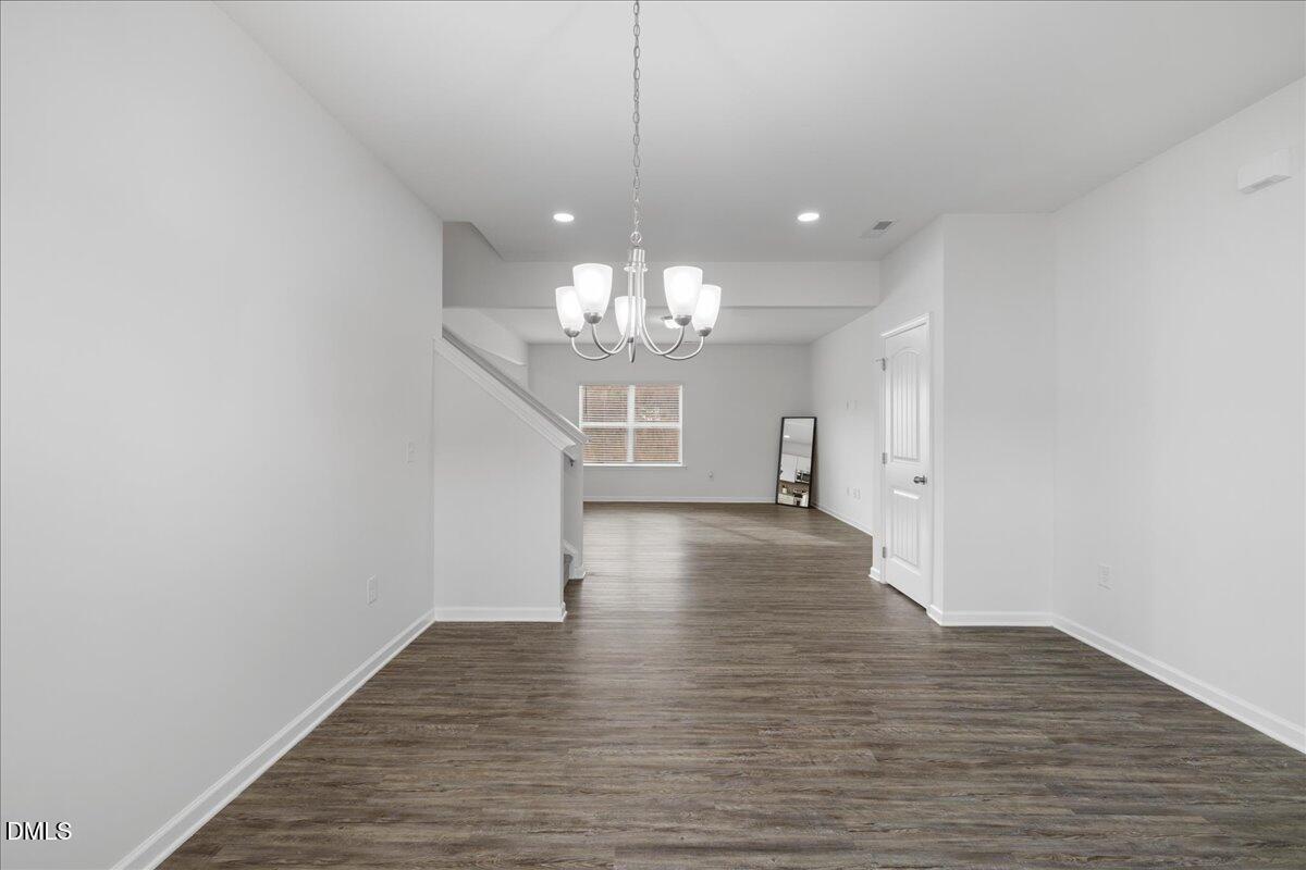 125 Flying Point Lane Clayton, NC 27520 - Photo 8 of 50 a view of a hallway with wooden floor and a chandelier