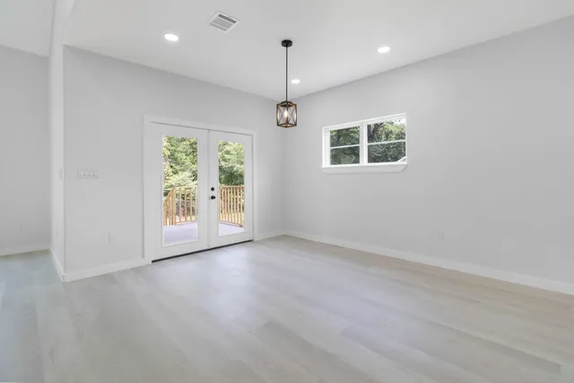 an empty room with windows and chandelier