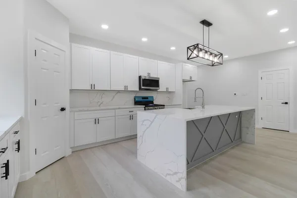a kitchen with kitchen island granite countertop stainless steel appliances a stove a sink and a refrigerator