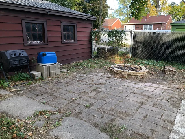 a backyard of a house with barbeque oven table and chairs