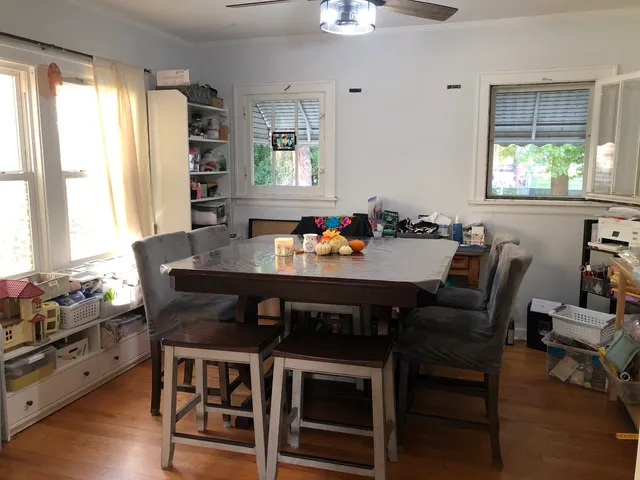 a dining room with furniture a window and wooden floor