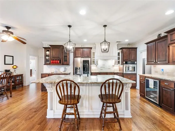 a kitchen with stainless steel appliances granite countertop a kitchen island a stove and a cabinets