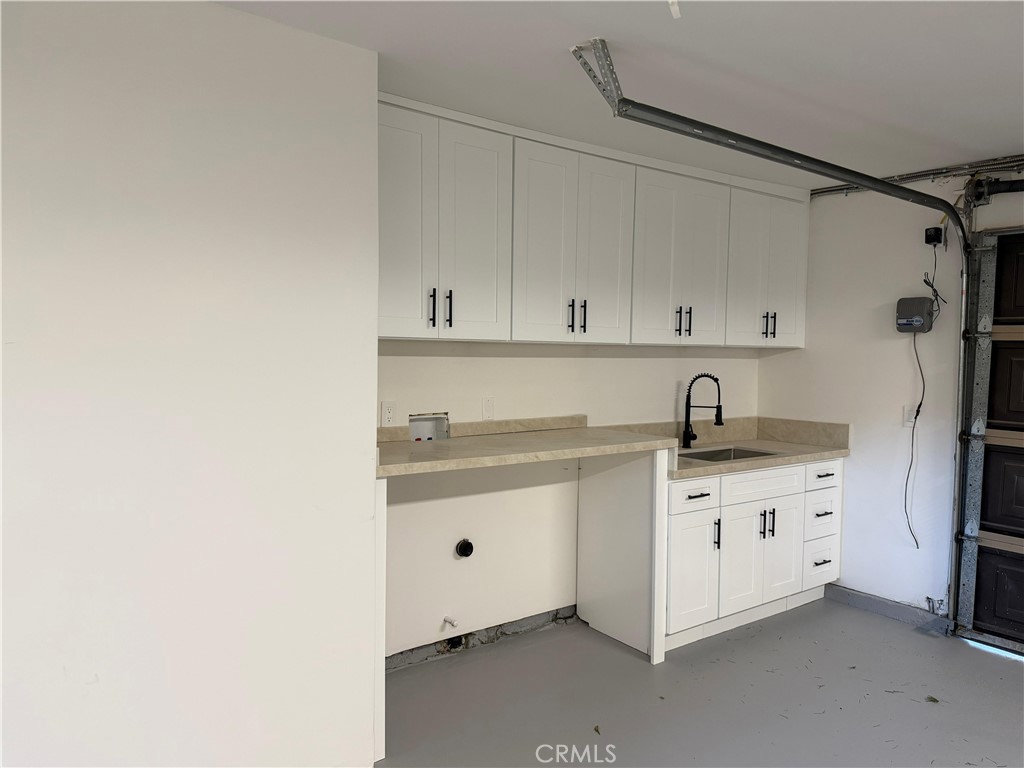 5365 Lewis Road Agoura Hills, CA 91301 - Photo 19 of 21 a white kitchen with a sink and dishwasher a stove with white cabinets