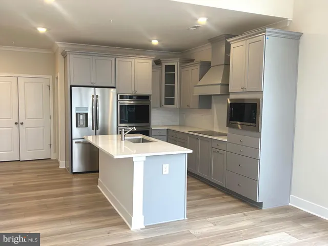 a kitchen with a refrigerator sink and cabinets