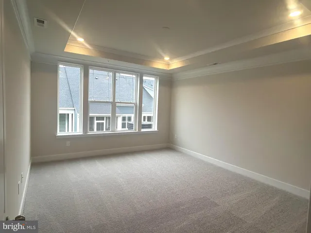 an empty room with a windows and chandelier