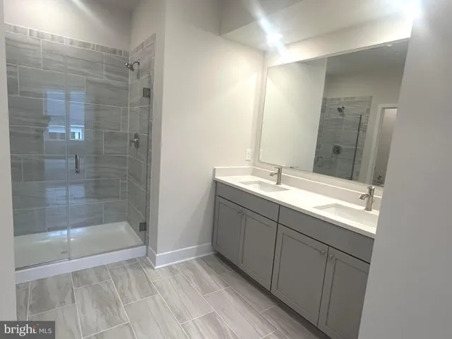a bathroom with a shower sink and mirror