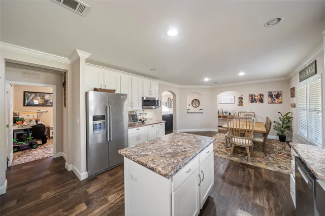 a kitchen with refrigerator and chairs