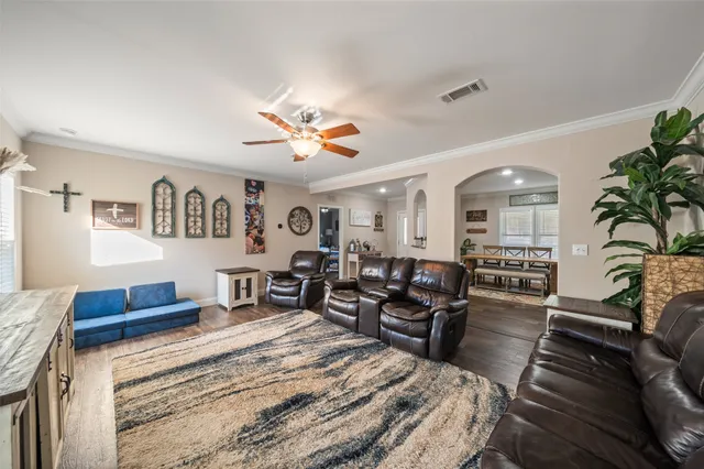 a living room with furniture kitchen view and a potted plant