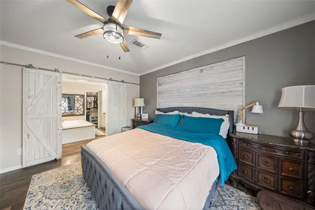 a bedroom with a large bed and a chandelier