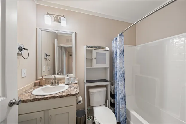 a bathroom with a granite countertop sink toilet and shower