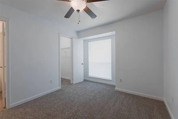 an empty room with chandelier fan