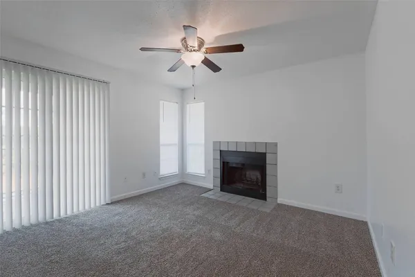 a view of empty room with fan and fireplace