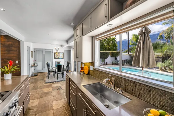 a kitchen with a sink and large windows
