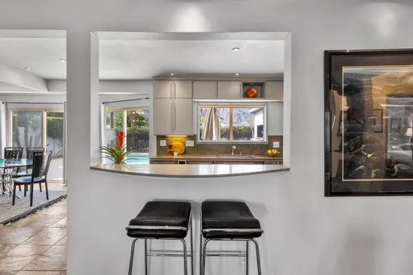 a kitchen with a sink and chairs
