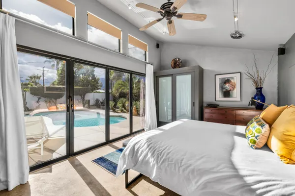 a bedroom with a bed and large mirror