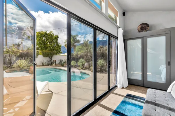 a bedroom with a bed and glass door