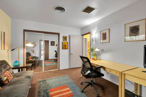 a spacious bedroom with a bed and wooden floor