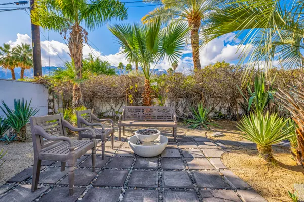 a view of a patio with table and chairs potted plants and wooden fence