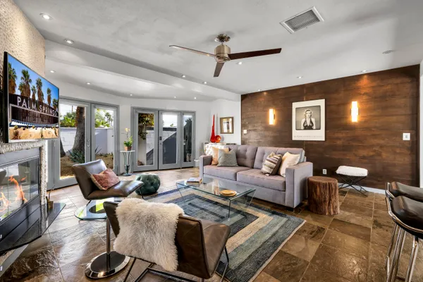 a living room with furniture a flat screen tv and a fireplace
