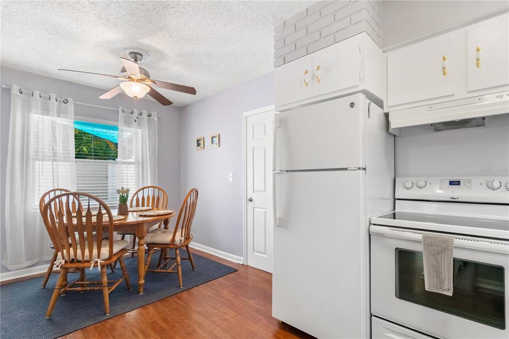 5596 100th Way North St. Petersburg, FL 33708 - Photo 23 of 67 a kitchen with stainless steel appliances granite countertop a dining table chairs a refrigerator and a stove top oven