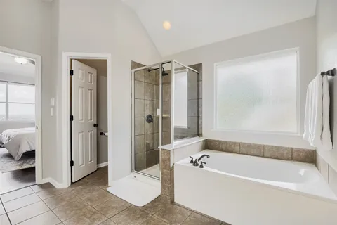 a bathroom with a tub shower and toilet