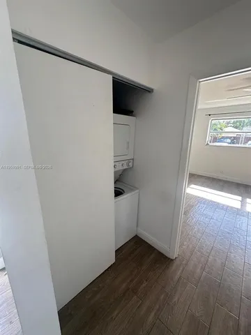 an empty room with wooden floor cabinet and closet