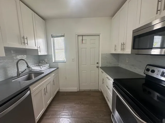 a kitchen with a sink stove and cabinets