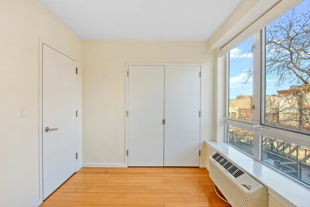 a bedroom with a bed and a large window with outer view