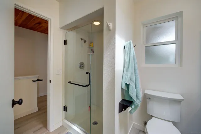 a bathroom with a granite countertop shower a toilet and a sink