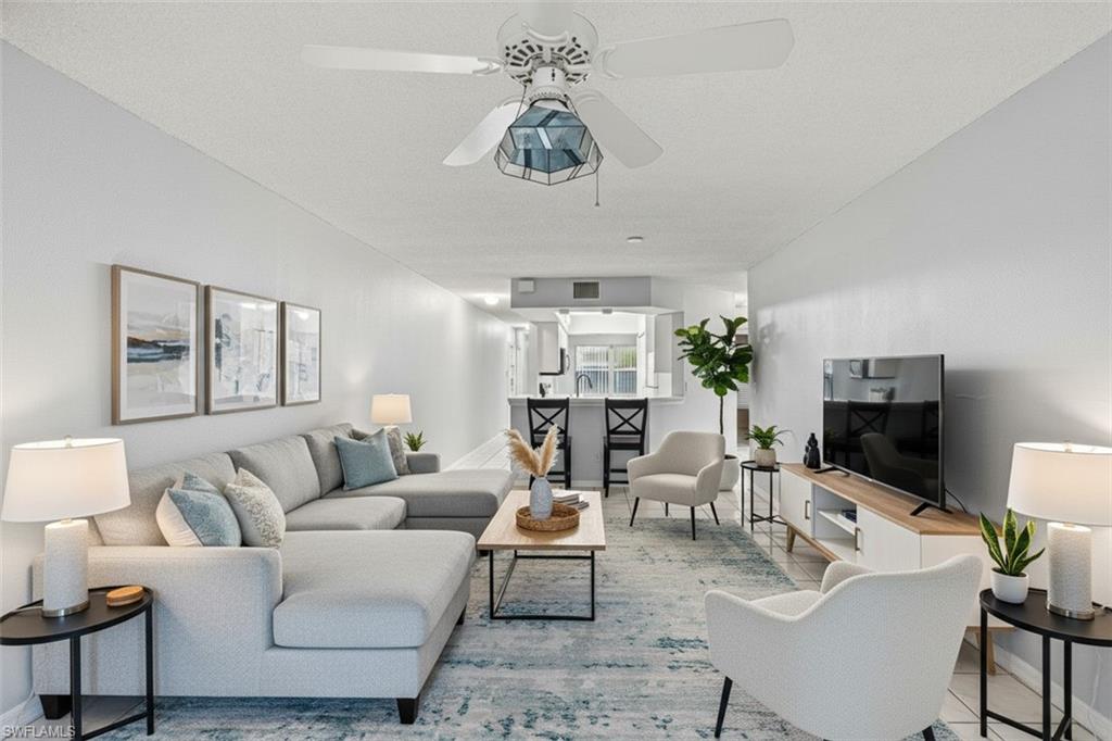 Living area virtual staged featuring baseboards and ceiling fan