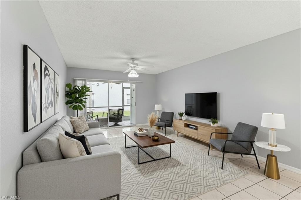 161 Wading Bird Circle, Unit L101 Naples, FL 34110 - Photo 12 of 44 Living room virtual staged featuring light tile patterned flooring, a ceiling fan, and a textured ceiling