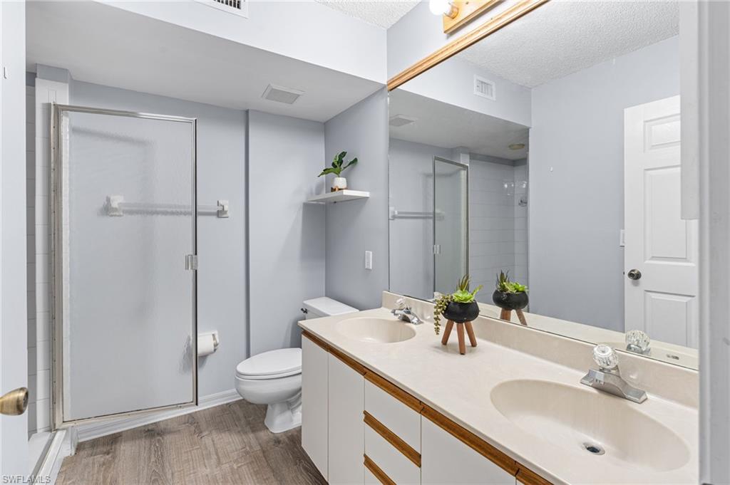 161 Wading Bird Circle, Unit L101 Naples, FL 34110 - Photo 15 of 35 a bathroom with a sink a toilet and shower