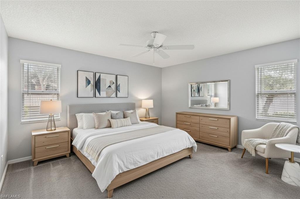161 Wading Bird Circle, Unit L101 Naples, FL 34110 - Photo 15 of 44 Master Bedroom virtual staged with carpet floors, a ceiling fan, and a textured ceiling
