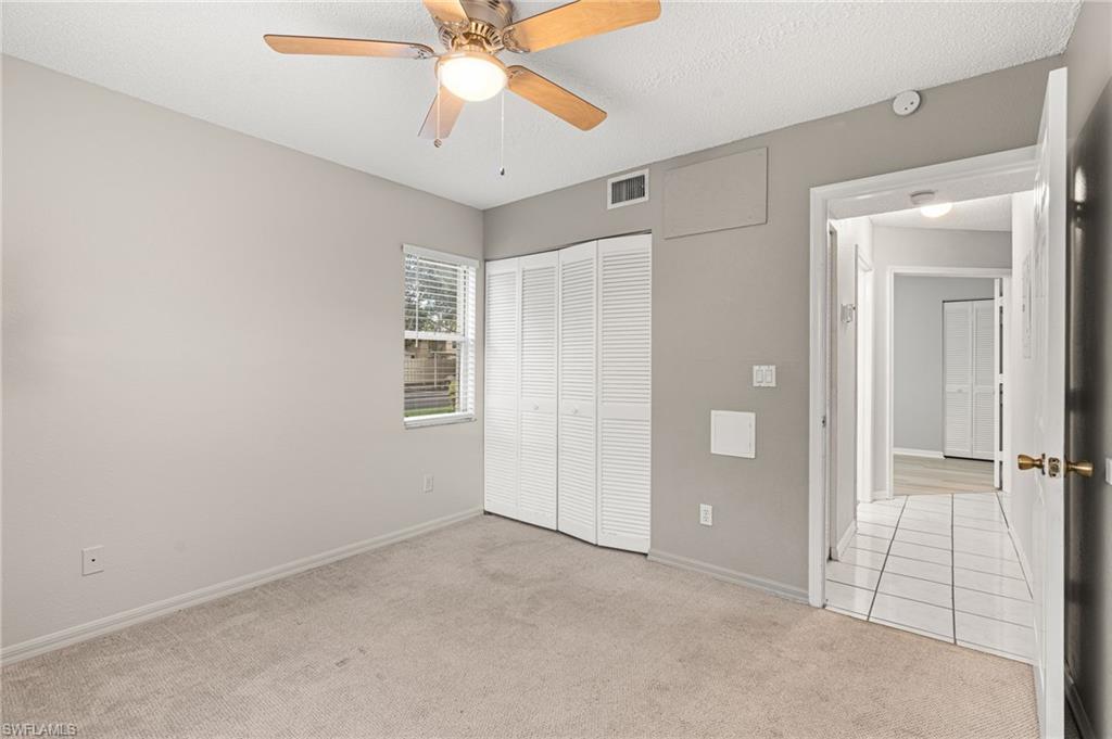 161 Wading Bird Circle, Unit L101 Naples, FL 34110 - Photo 19 of 35 an empty room with closet and a chandelier fan