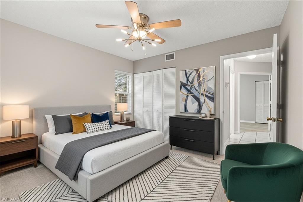 161 Wading Bird Circle, Unit L101 Naples, FL 34110 - Photo 24 of 44 Bedroom virtual staged featuring light carpet, a closet, and a ceiling fan