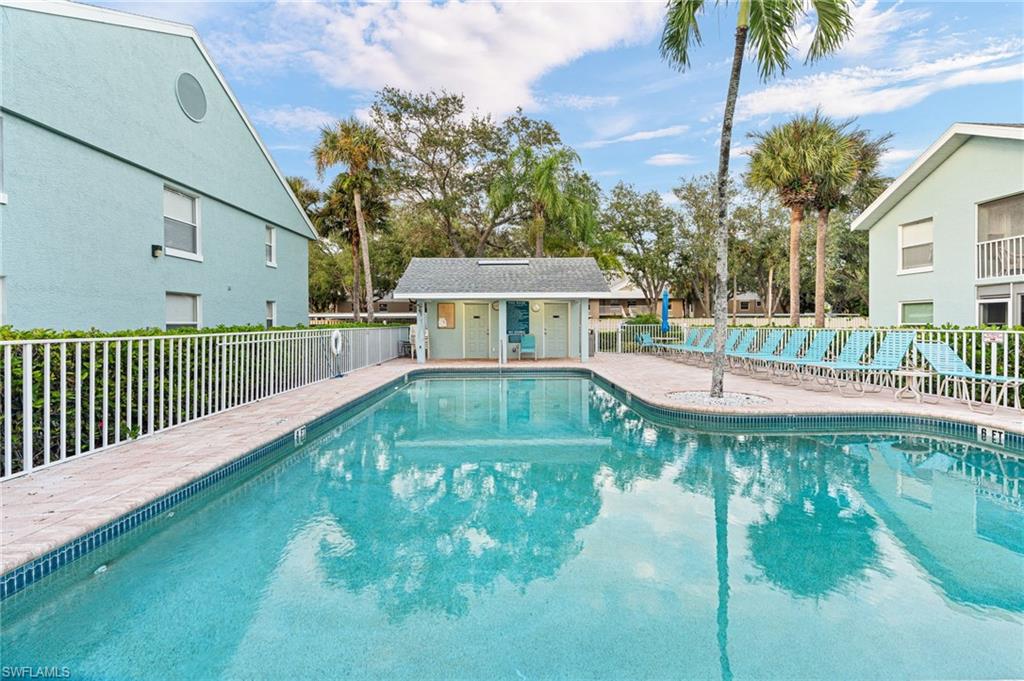 161 Wading Bird Circle, Unit L101 Naples, FL 34110 - Photo 27 of 35 a view of a swimming pool with a patio and a yard