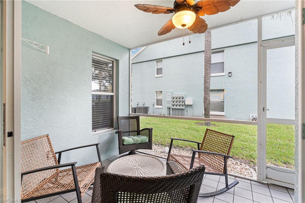 161 Wading Bird Circle, Unit L101 Naples, FL 34110 - Photo 29 of 44 Screened patio with ceiling fan and a patio