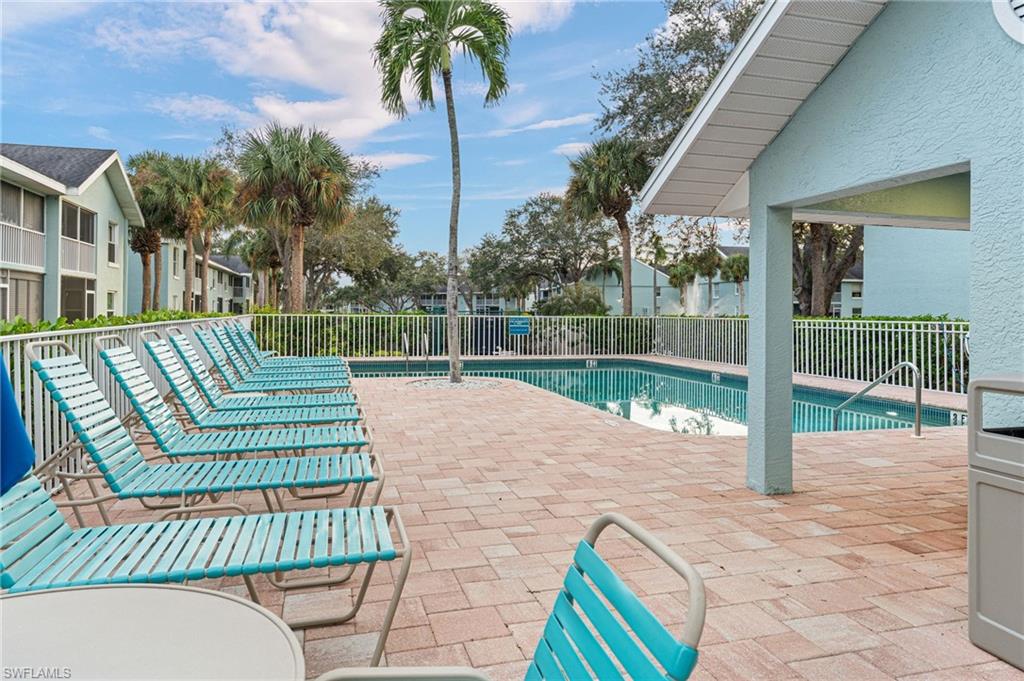 161 Wading Bird Circle, Unit L101 Naples, FL 34110 - Photo 38 of 44 Community pool featuring a patio area