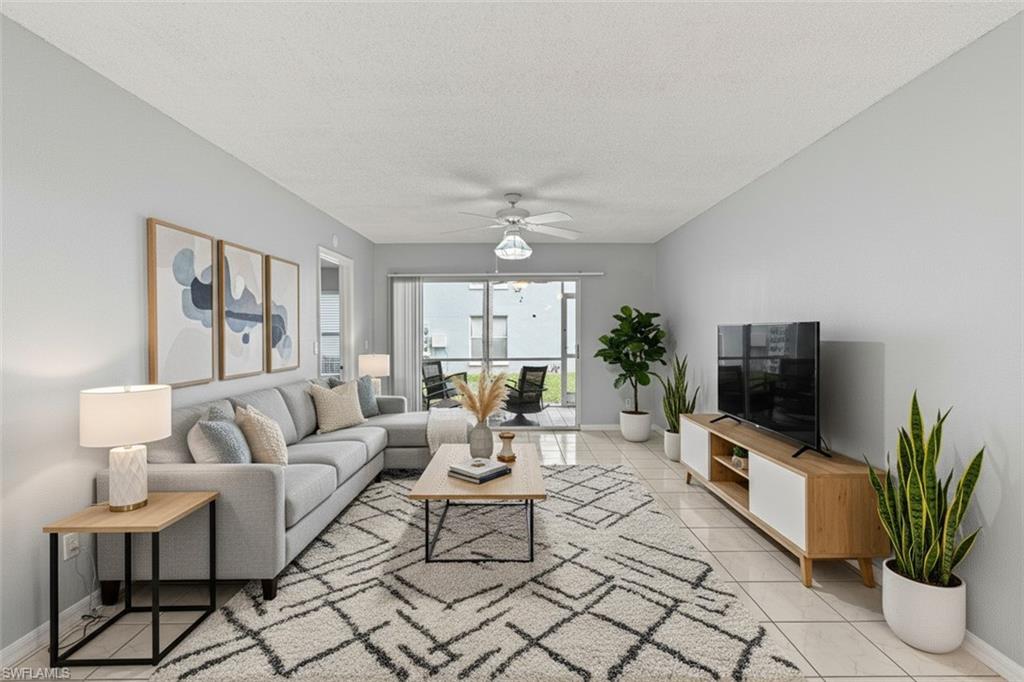 161 Wading Bird Circle, Unit L101 Naples, FL 34110 - Photo 10 of 44 Living room virtual staged with a textured ceiling and a ceiling fan