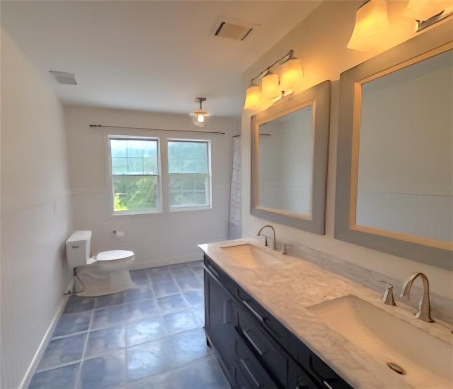 1599 Lower River Road Covington, GA 30016 - Photo 10 of 23 a bathroom with a granite countertop sink toilet a large mirror and a window