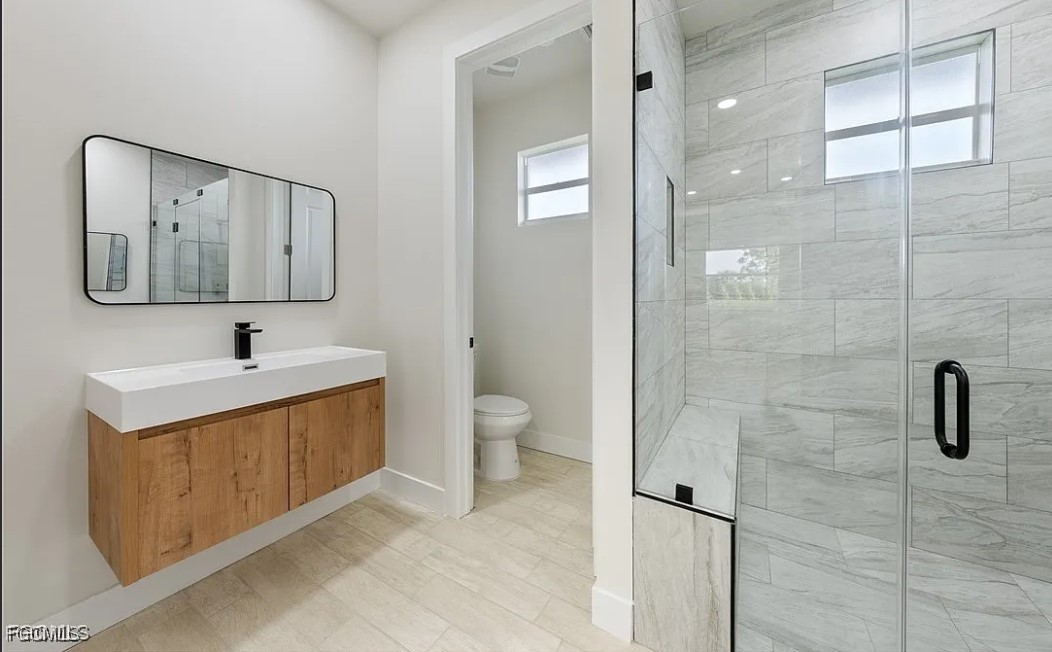 2719 42nd Street West Lehigh Acres, FL 33971 - Photo 15 of 20 a bathroom with a toilet sink and shower