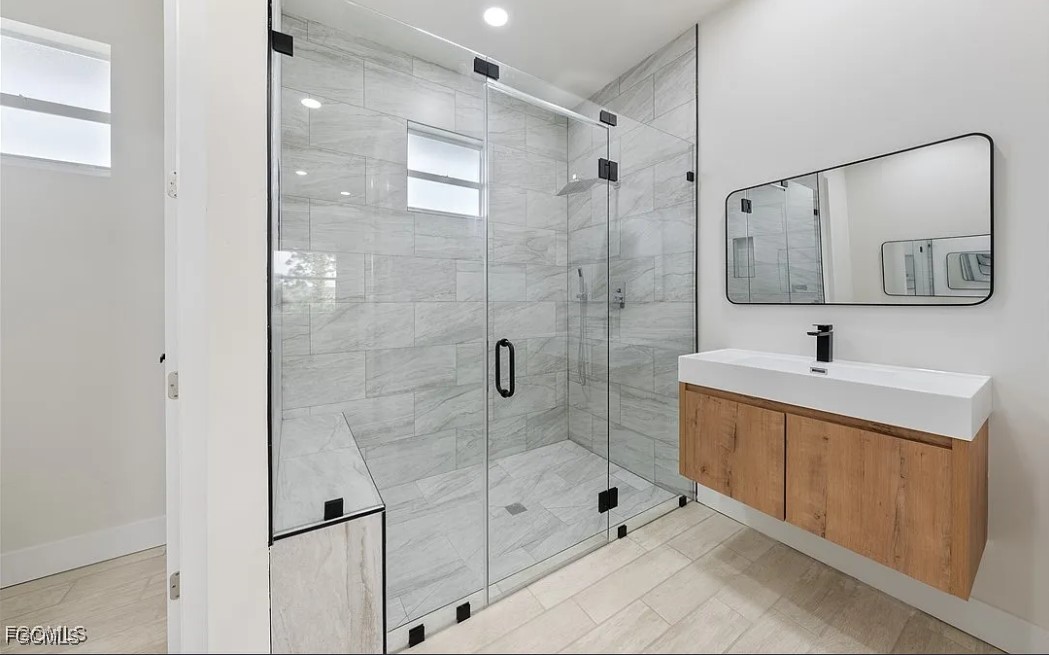 2719 42nd Street West Lehigh Acres, FL 33971 - Photo 16 of 20 a bathroom with a shower sink and mirror