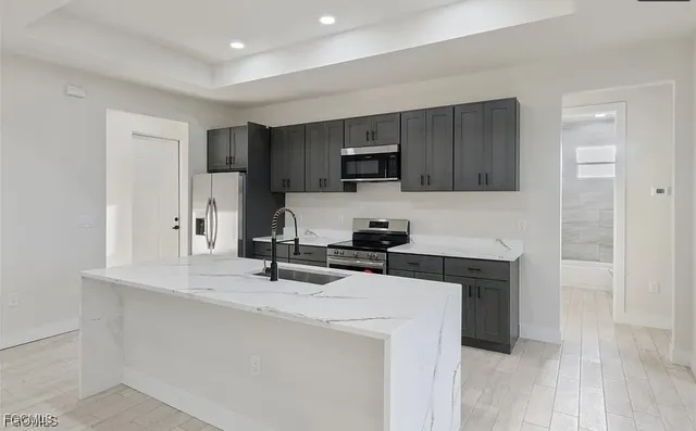 a kitchen with a sink a stove a microwave and cabinets